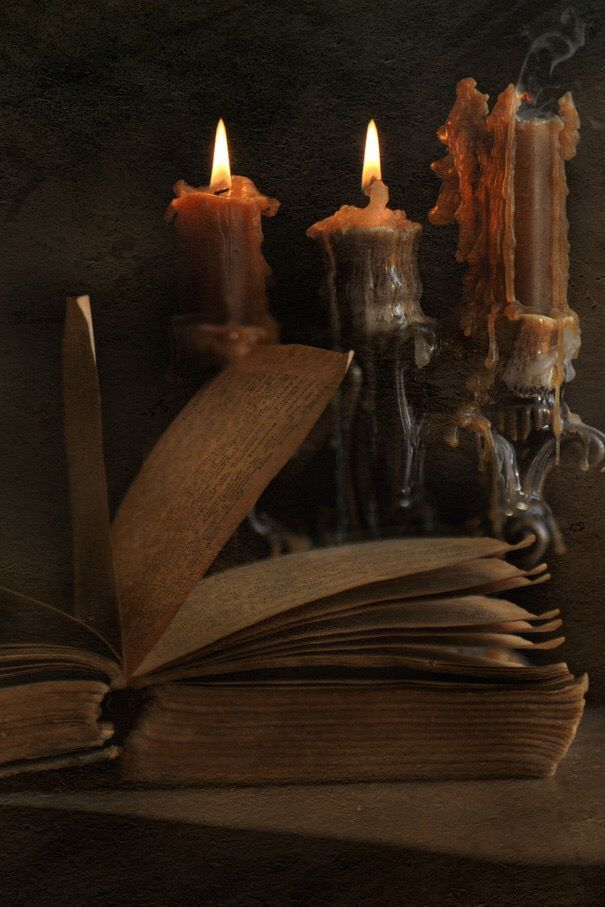 Stack of dark romance novels surrounded by candles and roses, styled as sacred coven relics for initiates.